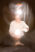 Auf diesem Foto wird ein "Seelenfoto" einer Frau gezeigt. Sie hält einen Lichtball in der Hand und einer leuchtet hinter ihr. Es ist eine Studioaufnahme mit schwarzem Hintergrund der weiche Falten wirft. Es ist ein mystisches Bild, was Ruhe und Kraft ausstrahlt.