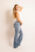 Sedcardfoto als Ganzkörper einer jungen Frau in Jeans und weißem Oberteil.